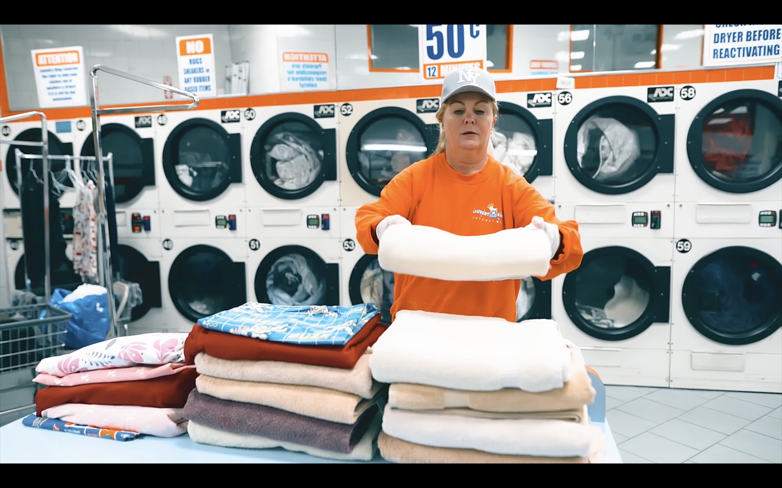 A Laundry King team member folding clean towels by hand at the Brooklyn shop